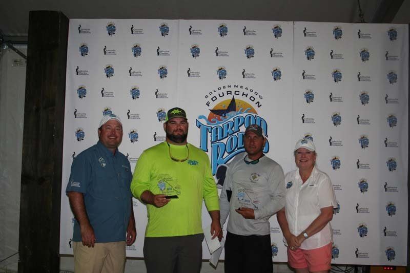 A group of people are posing for a picture in front of a wall.