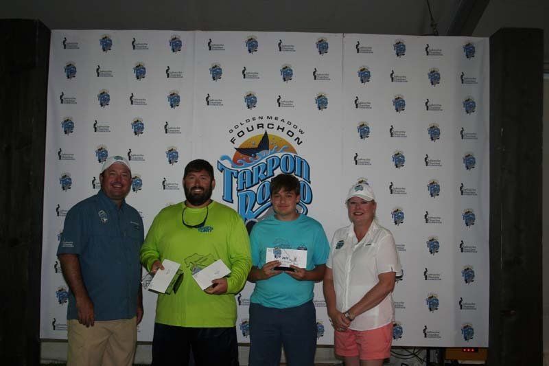 A group of people standing in front of a wall that says triumph