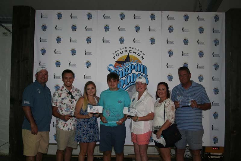A group of people are posing for a picture in front of a wall.