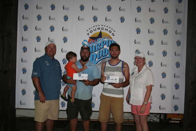 A group of people posing for a picture in front of a banner that says splash pad