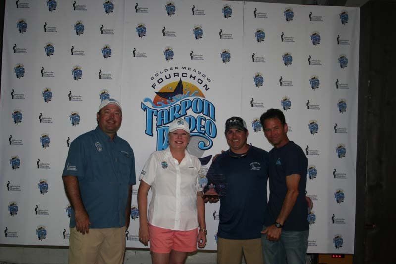 Four people standing in front of a wall that says fourchon