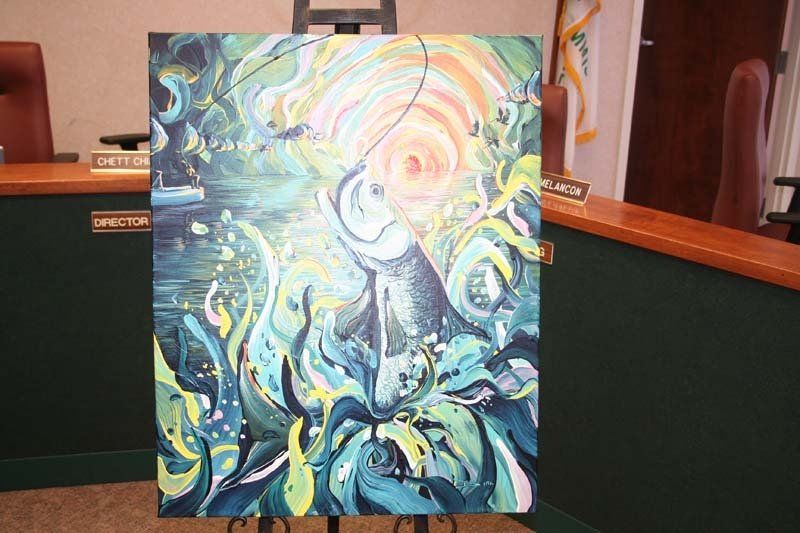 A painting of a dolphin is displayed on an easel