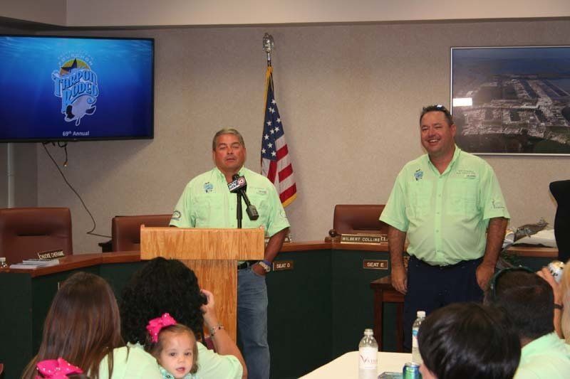 Two men standing at a podium in front of a group of people