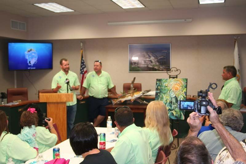 A group of people are sitting around a table watching a presentation