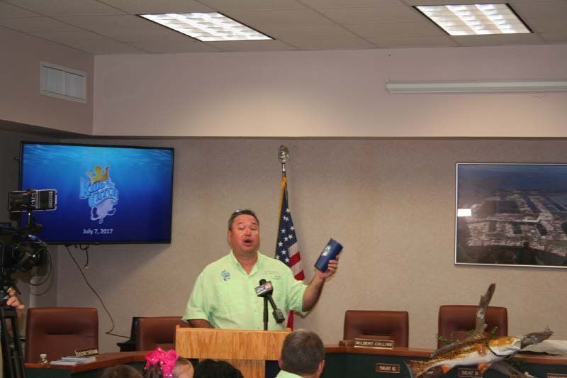 A man stands at a podium holding a can of soda