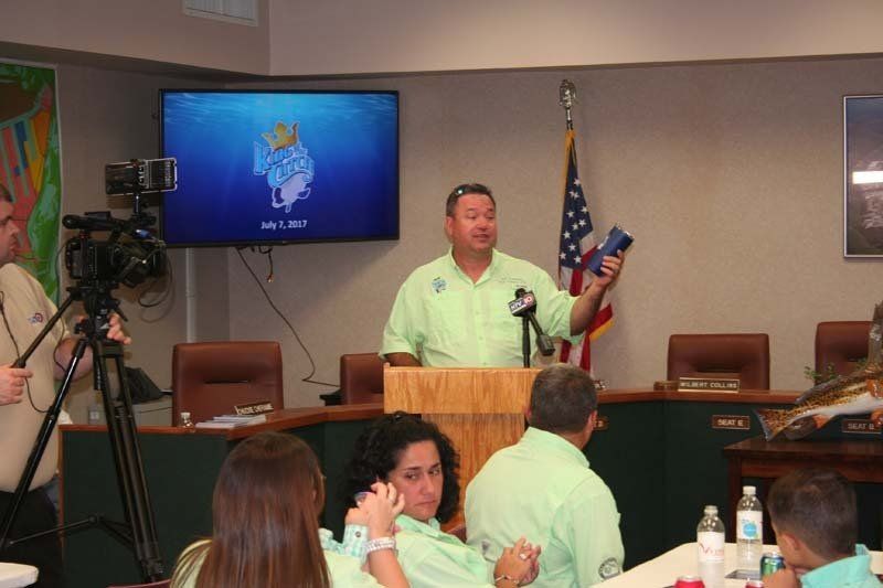 A man stands at a podium giving a presentation to a group of people