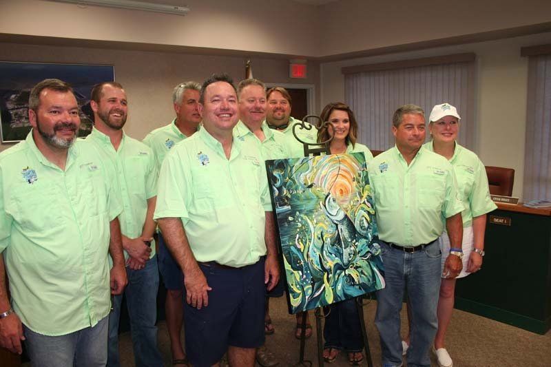 A group of people in green shirts are posing for a picture.
