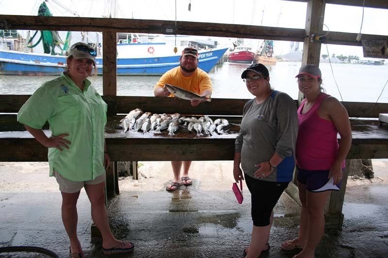 A group of people standing in front of a table with fish on it