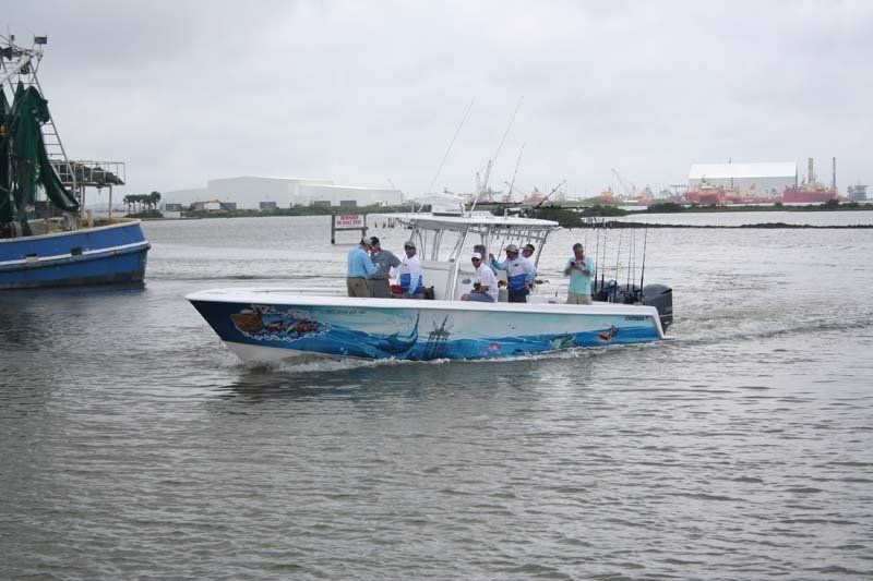 A boat with people on it is floating on top of a body of water.