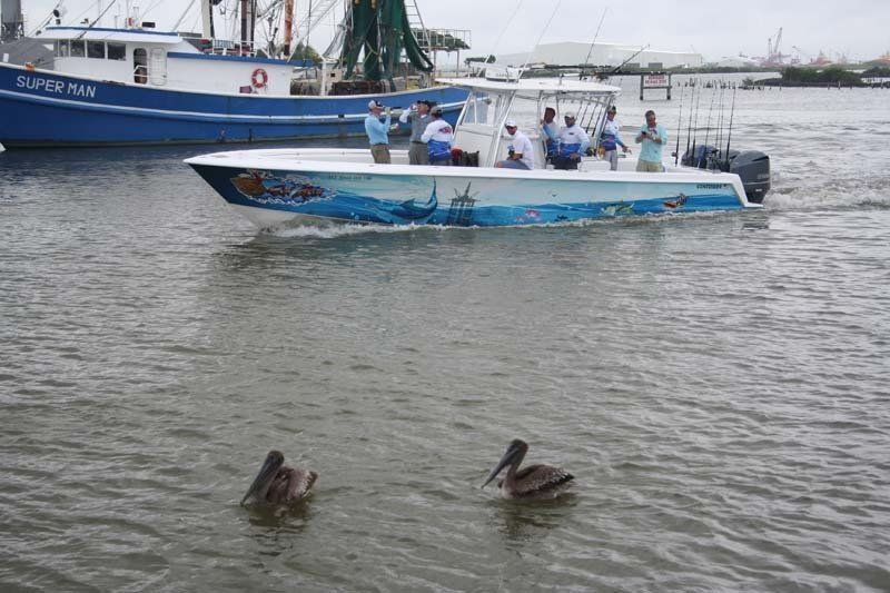 Two pelicans are swimming near a boat in the water