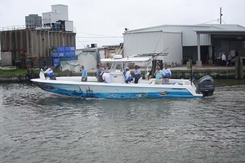 A boat with people on it is floating on a body of water.