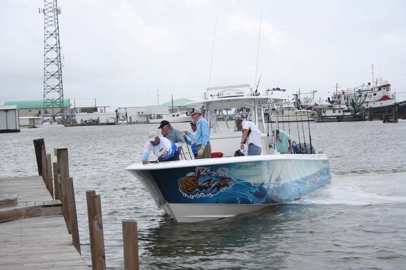 A group of people are riding on the back of a boat in the water.