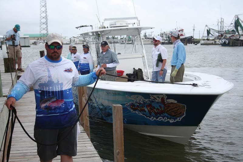 A man is standing on a dock next to a boat