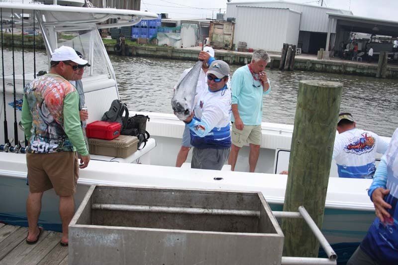 A group of men are standing on a dock next to a boat.