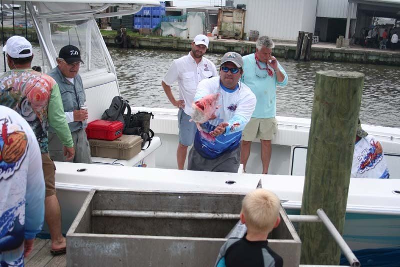 A group of men are standing on a boat in the water