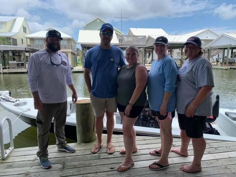 A group of people standing on a dock next to a boat.