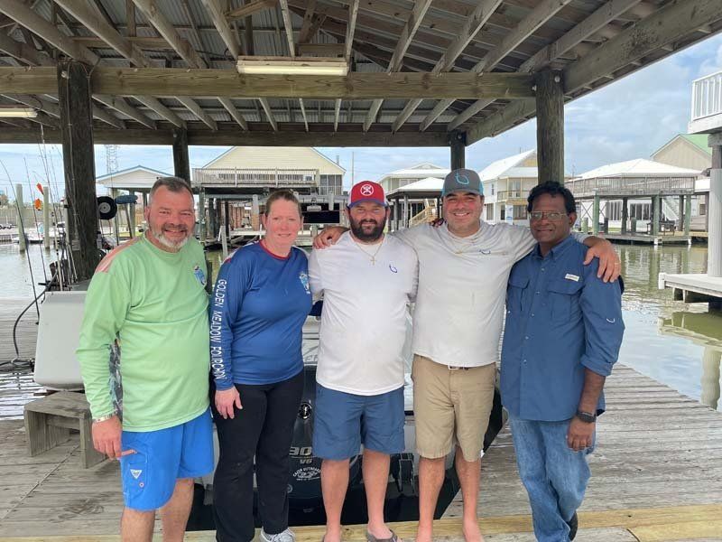 A group of people are posing for a picture on a dock.