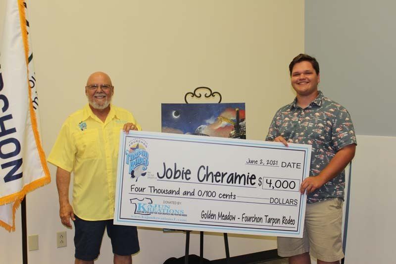 Two men are standing next to each other holding a large check.