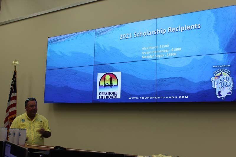 A man is giving a presentation in front of a large screen.