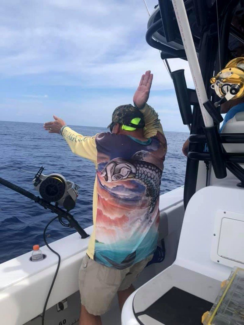 A man is fishing on a boat in the ocean.
