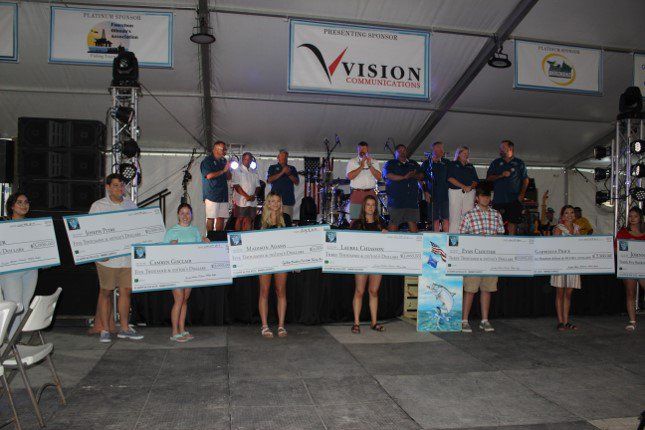 A group of people holding checks in front of a sign that says vision