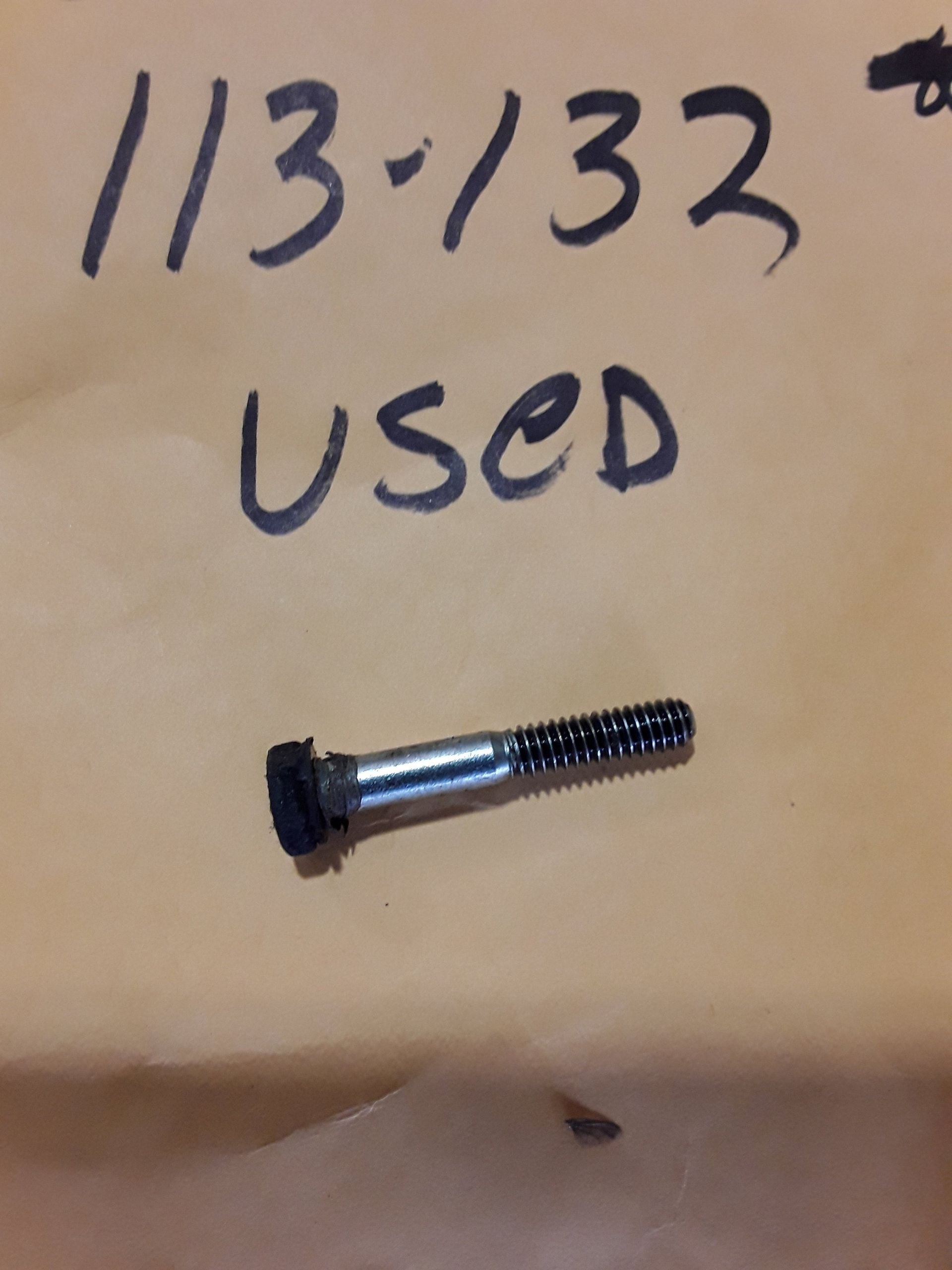 Small used screw on cardboard labeled “11/32 used”