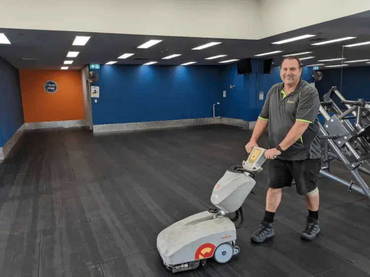 Man Cleaning a Gym Floor With an Industrial Floor Cleaner — Jamac Cleaning Services in Cardiff, NSW