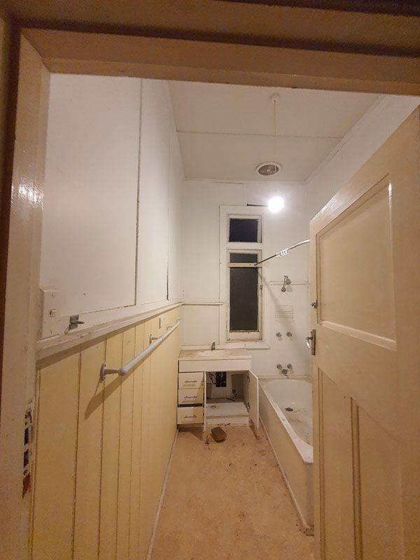 A bathroom with a bathtub and a window.