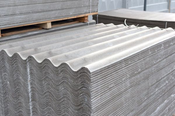 A stack of asbestos sheets sitting on top of each other on a pallet.