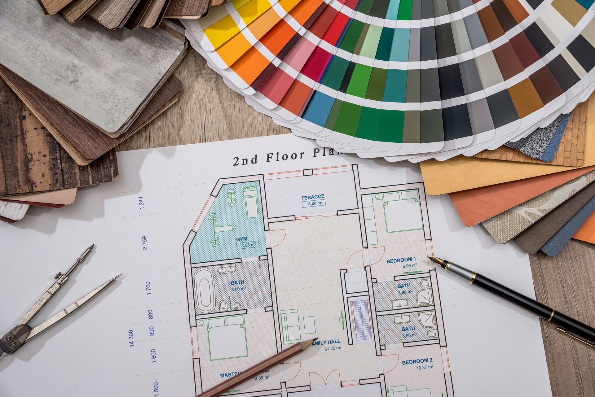 A floor plan of a house is sitting on a table next to a color wheel.
