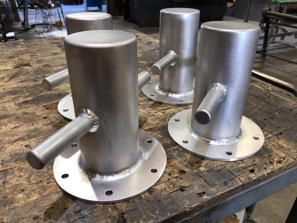 A Group of Metal Pipes Are Sitting on Top of A Wooden Table — Shearwater Engineering in Forster, NSW