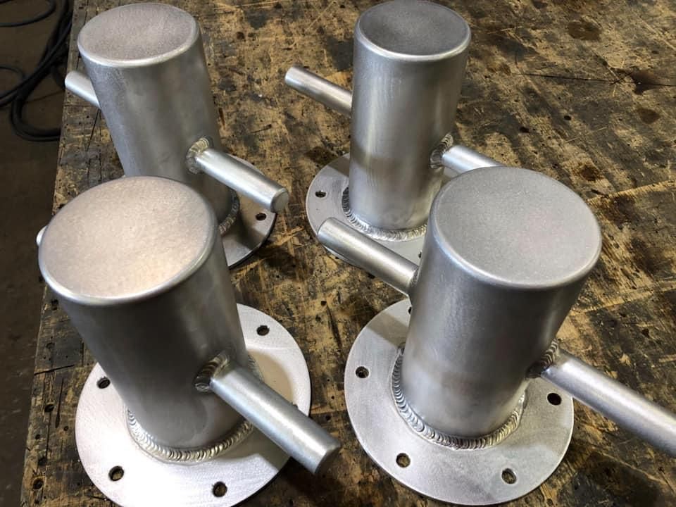 A Group of Metal Pipes Sitting on Top of A Wooden Table — Shearwater Engineering in Gloucester, NSW