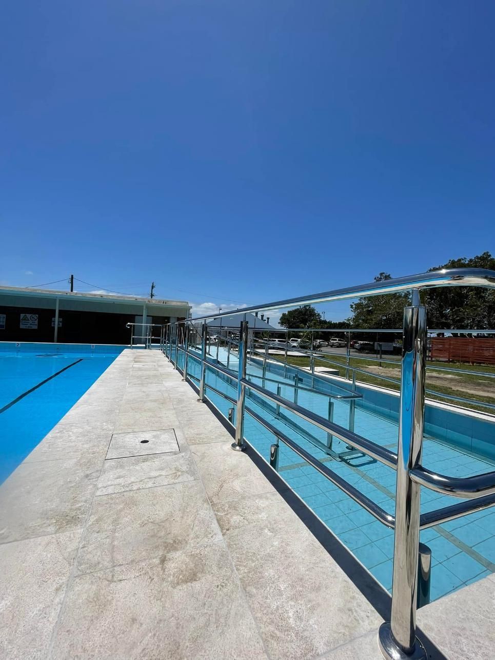 A Swimming Pool with A Stainless Steel Railing Surrounding It — Shearwater Engineering in Taree, NSW