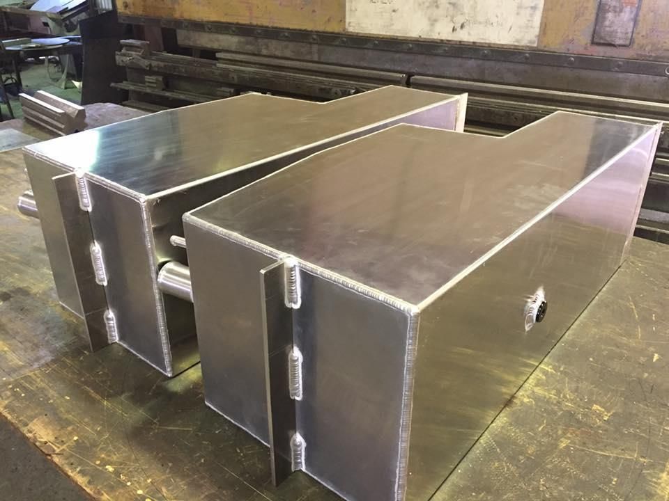 Two Aluminum Boxes Are Sitting on Top of A Wooden Table — Shearwater Engineering in Taree, NSW