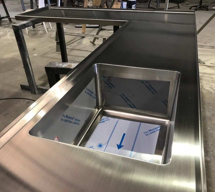 A Stack of Stainless Steel Sheets Are Stacked on Top of Each Other on A Table — Shearwater Engineering in Taree, NSW