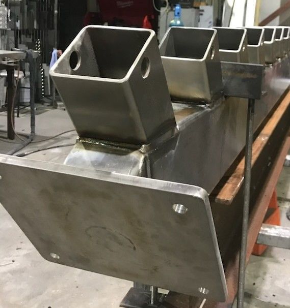 A Man Wearing a Welding Helmet Is Welding a Metal Pipe — Shearwater Engineering in Taree, NSW