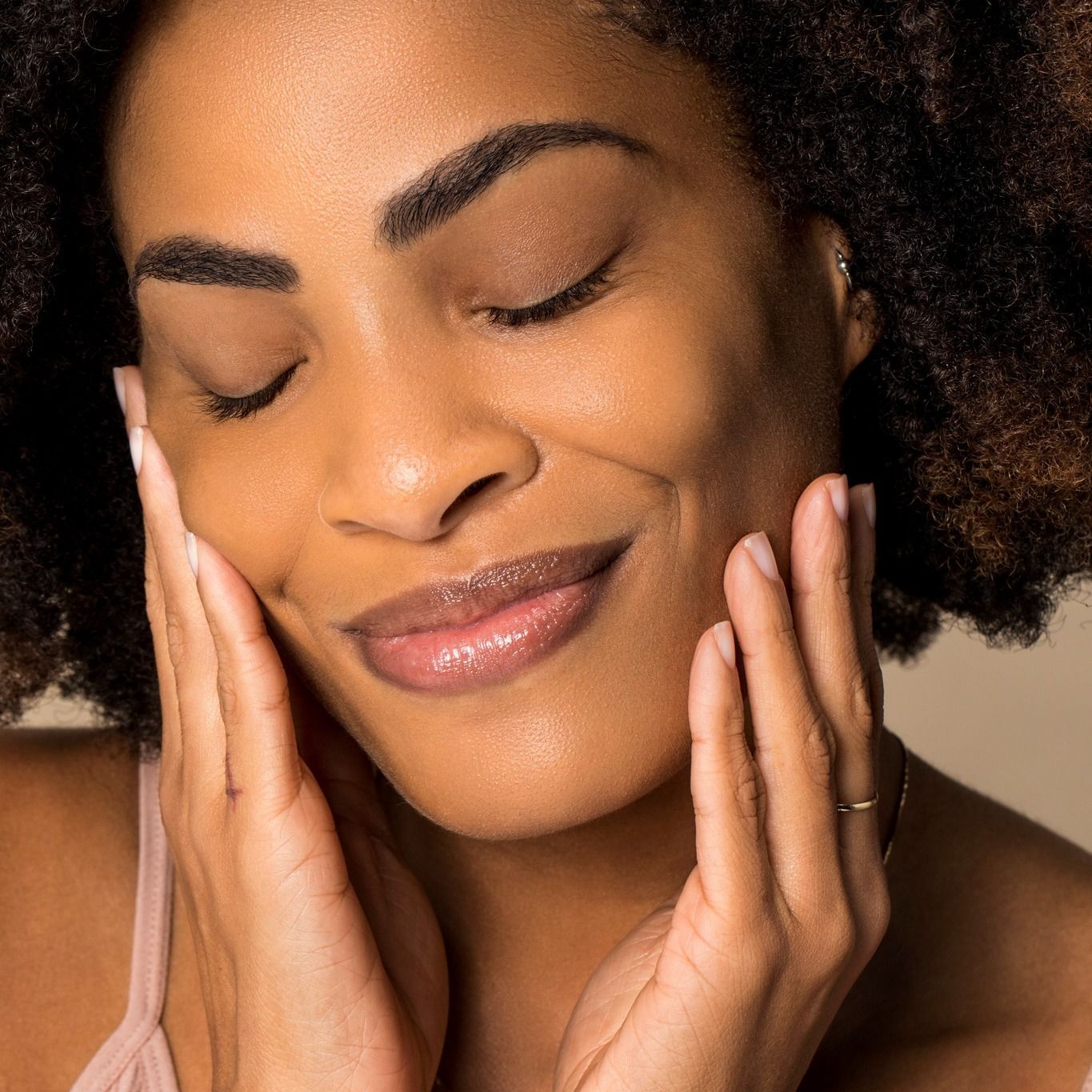 Woman touching her face and smiling for the camera