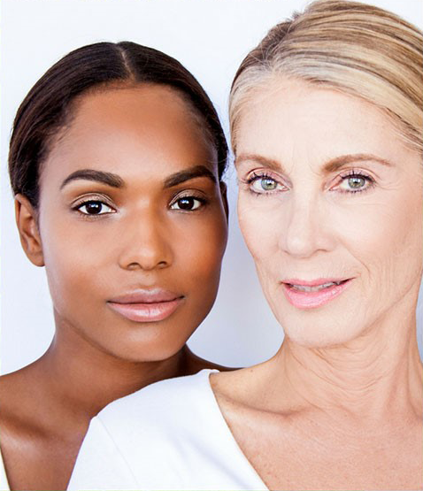 Two women are standing next to each other and smiling for the camera