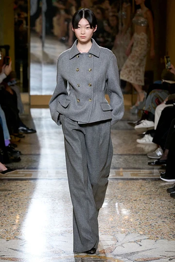 Asian woman in a grey pant suit