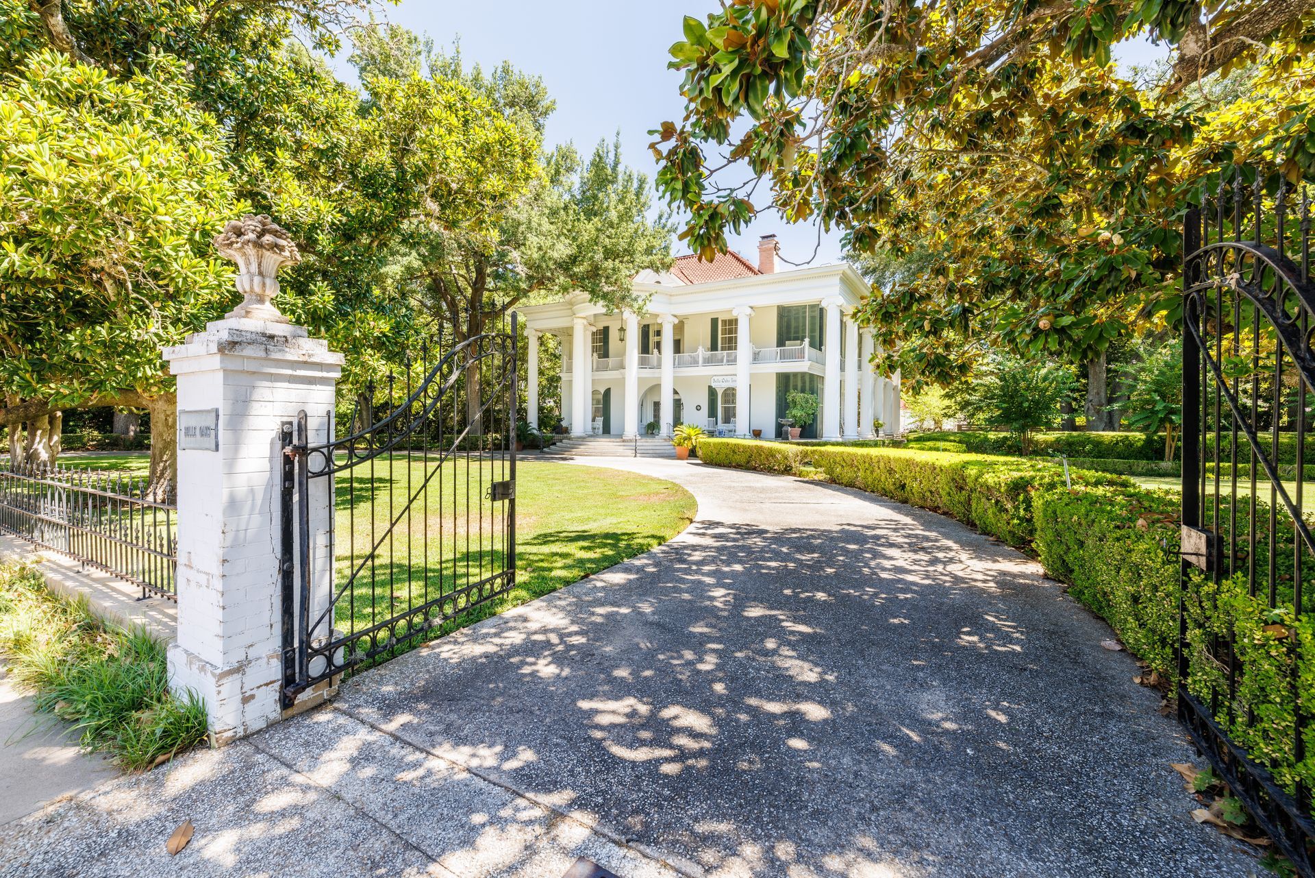 a large house with a large porch is surrounded by flowers .