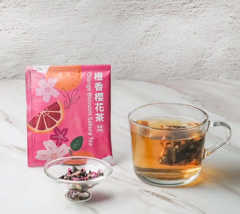 大理石檯面上放著一個茶包、一小碗乾散茶和一杯泡好的茶。