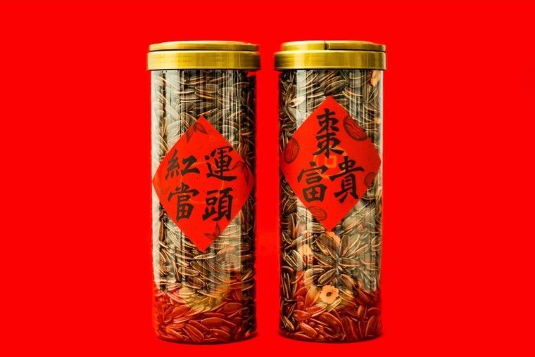 一個裝滿葵花籽的木碗，更多的葵花籽灑落在深色的石板上。