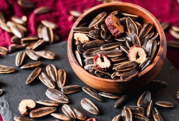 兩個優雅的紅色禮盒，飾有金色花卉圖案和金色提手，與深紅色背景相得益彰。