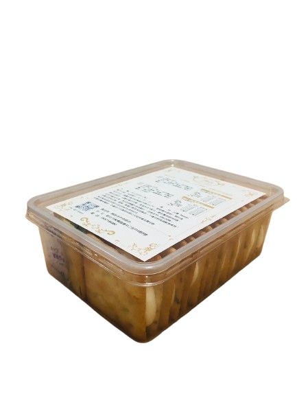 一個裝滿切片醃製食品的塑膠容器，上面貼著白色標籤，置於純白色背景上。