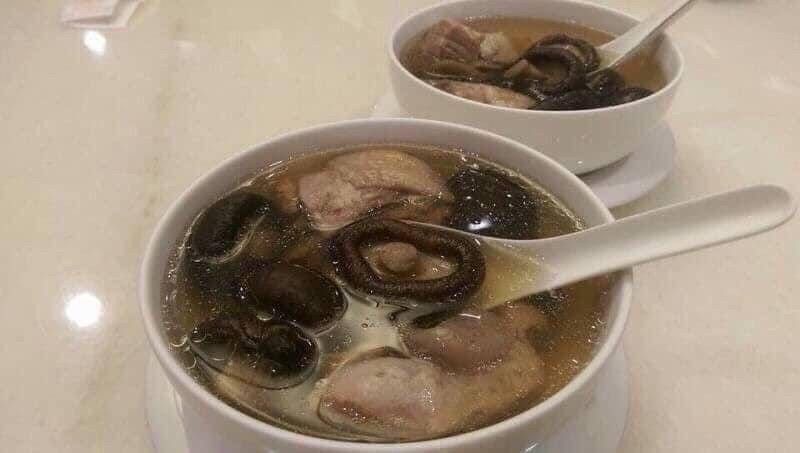 一盤乾香菇放在深色木板上，旁邊印有文字，宣傳新社冬季蘑菇，300克包裝。