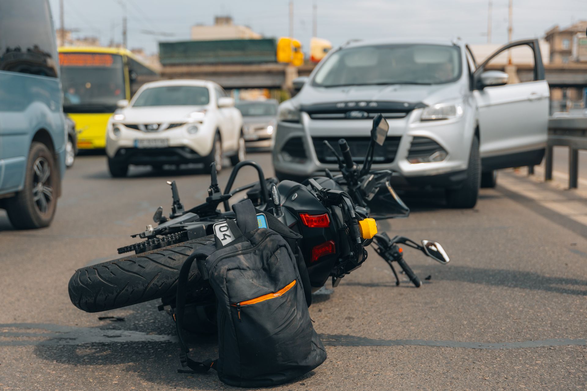 Motorcycle lying on road after a collision with a car on a city street.