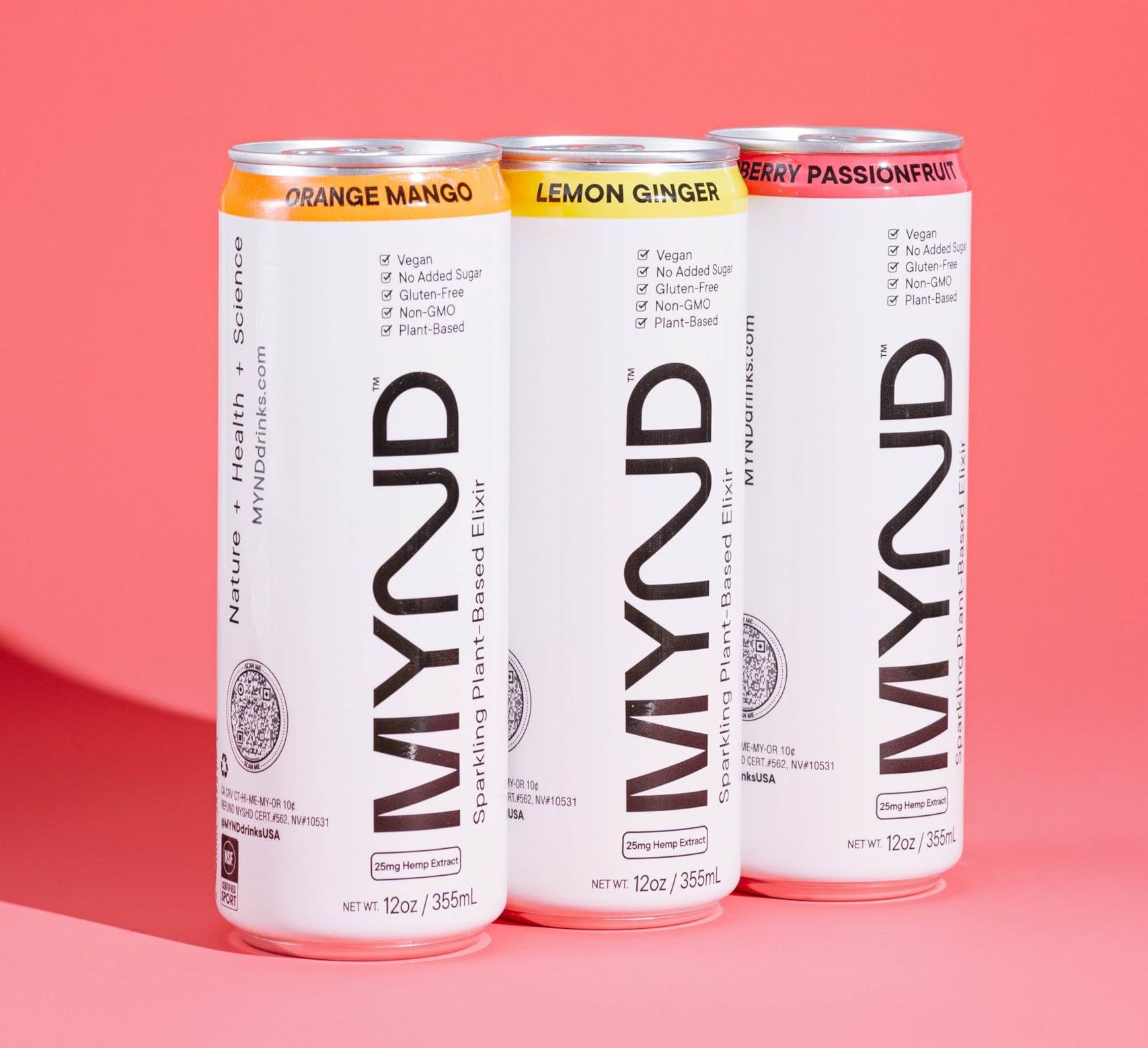 Three cans of mynd drink are sitting next to each other on a pink surface.