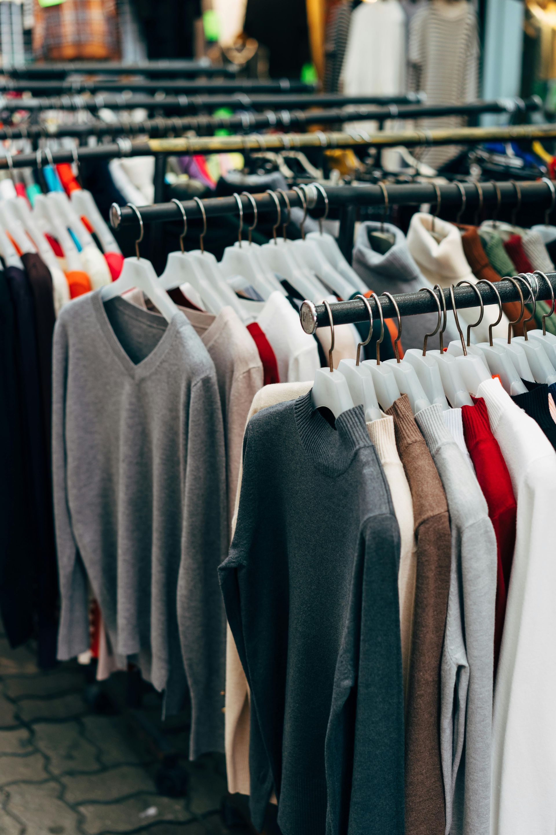 A bunch of clothes are hanging on racks in a store