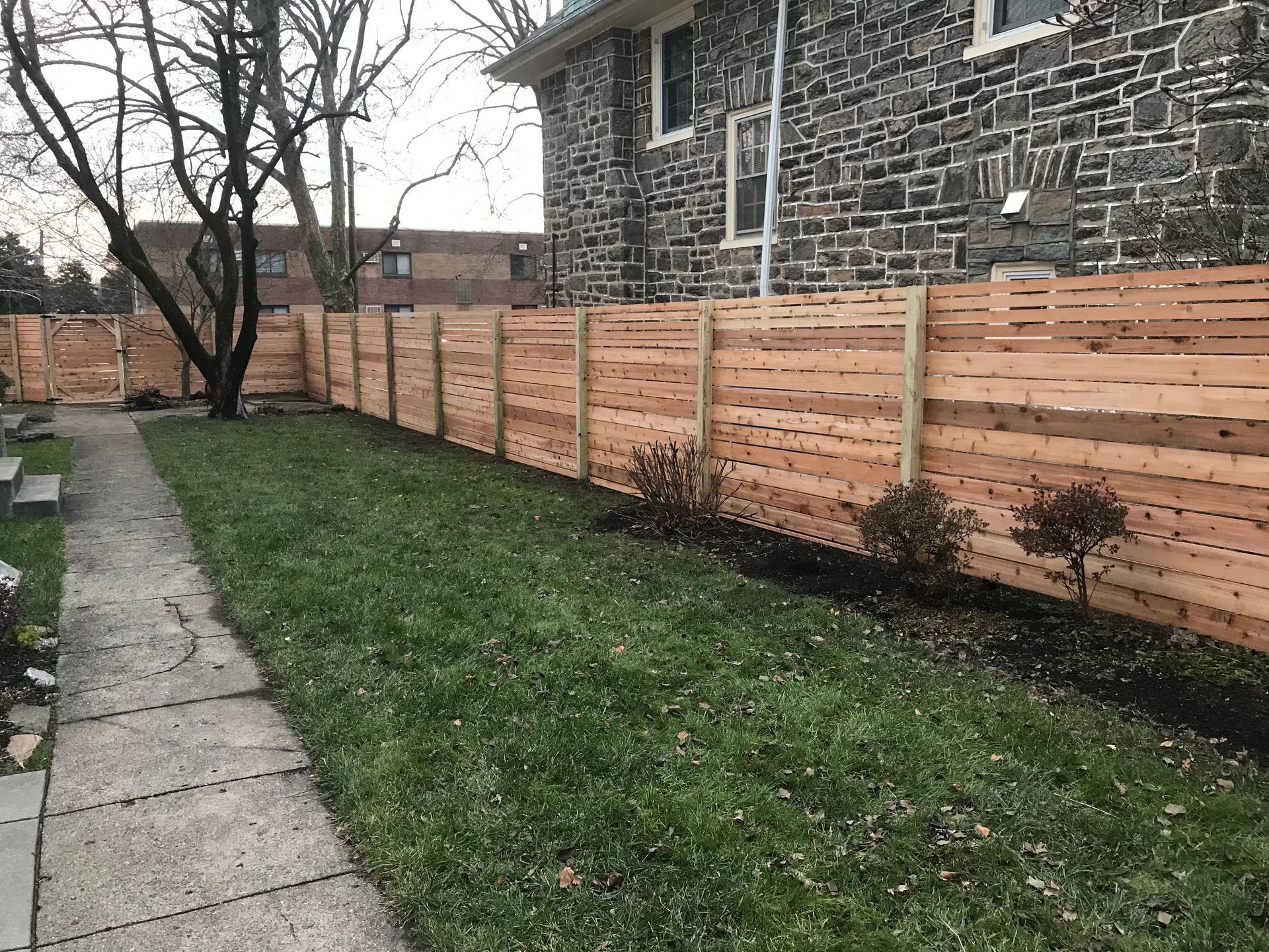 There is a wooden fence in the backyard of a house.