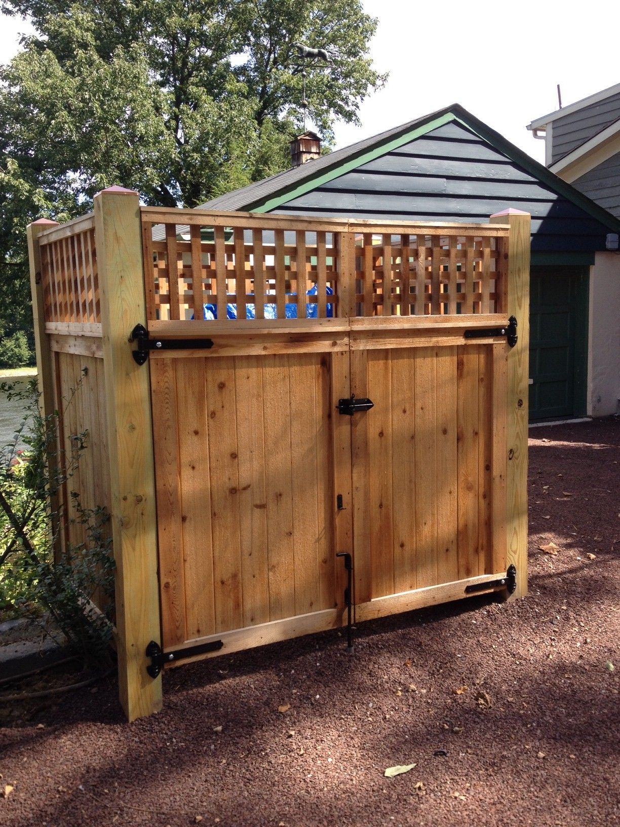 A wooden fence is sitting in front of a garage.